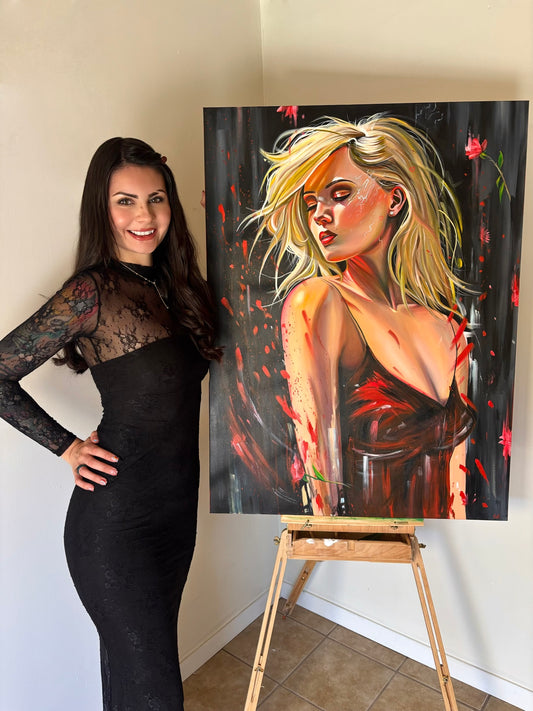 Woman standing next to a painting of a woman on an easel