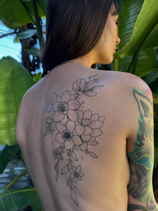 Gracey Ripa posing with a beautiful, decorative, floral temporary tattoo on her back.