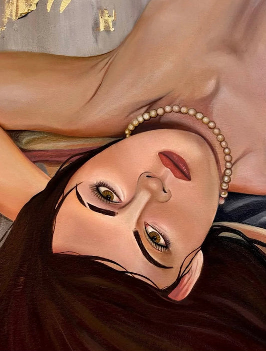 Artistic depiction of a woman's face with a pearl necklace and dark hair, lying on a surface.
