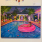 A colorful painting on canvas depicting a woman lounging in a pink float on a swimming pool at night, surrounded by palm trees and a modern house, displayed on a beige wall.